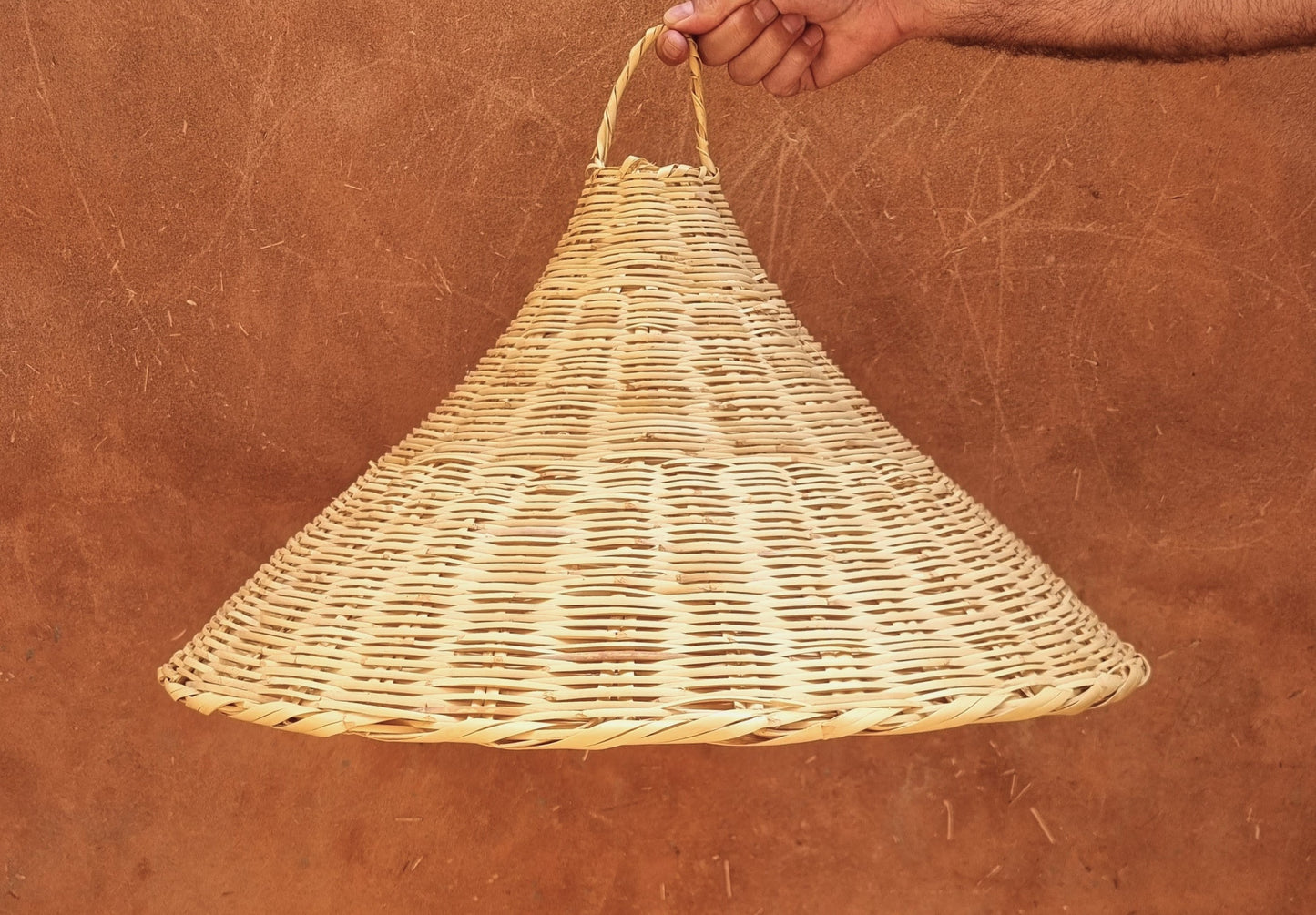 Suspension lumineuse en rotin tressé, offrant un éclairage chaleureux et naturel