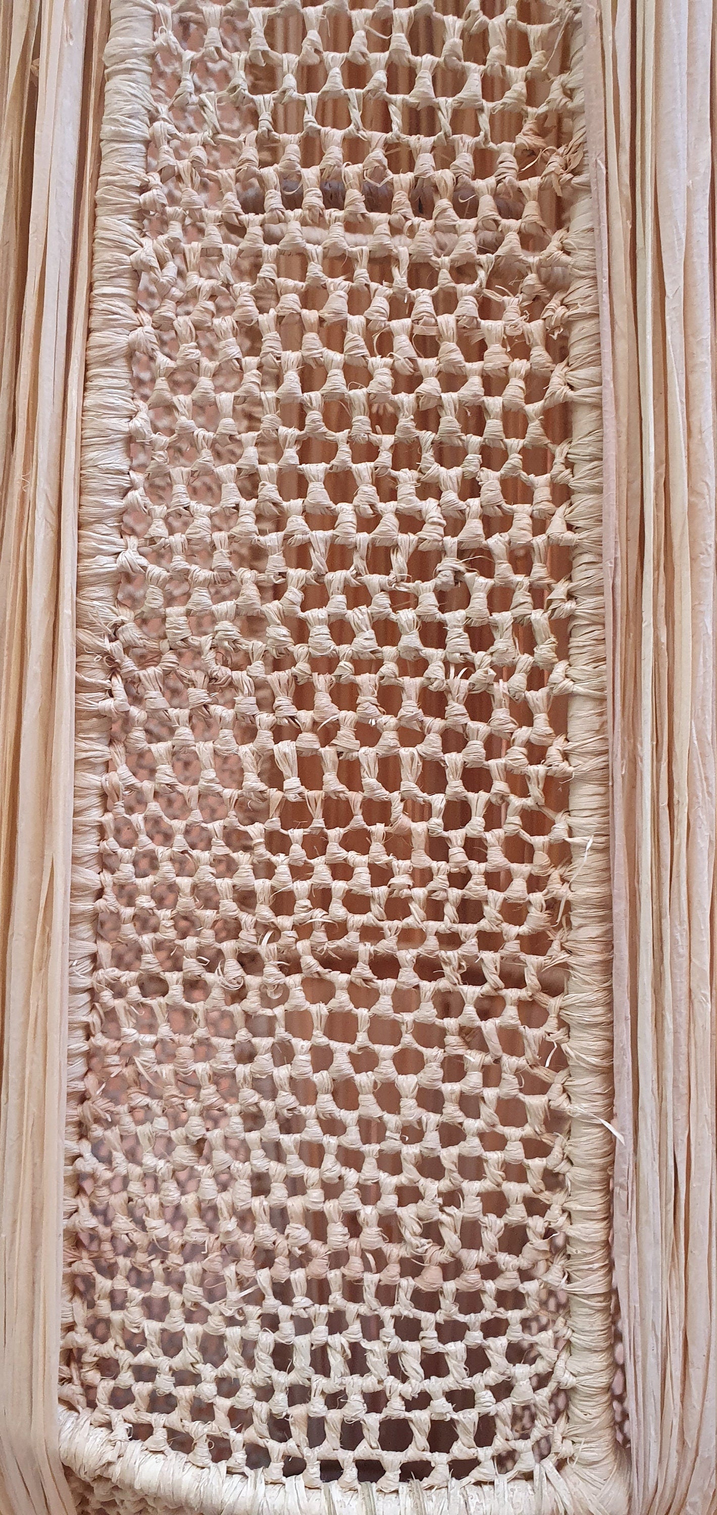 une suspension décorative en raphia avec une lanterne en dentelle.