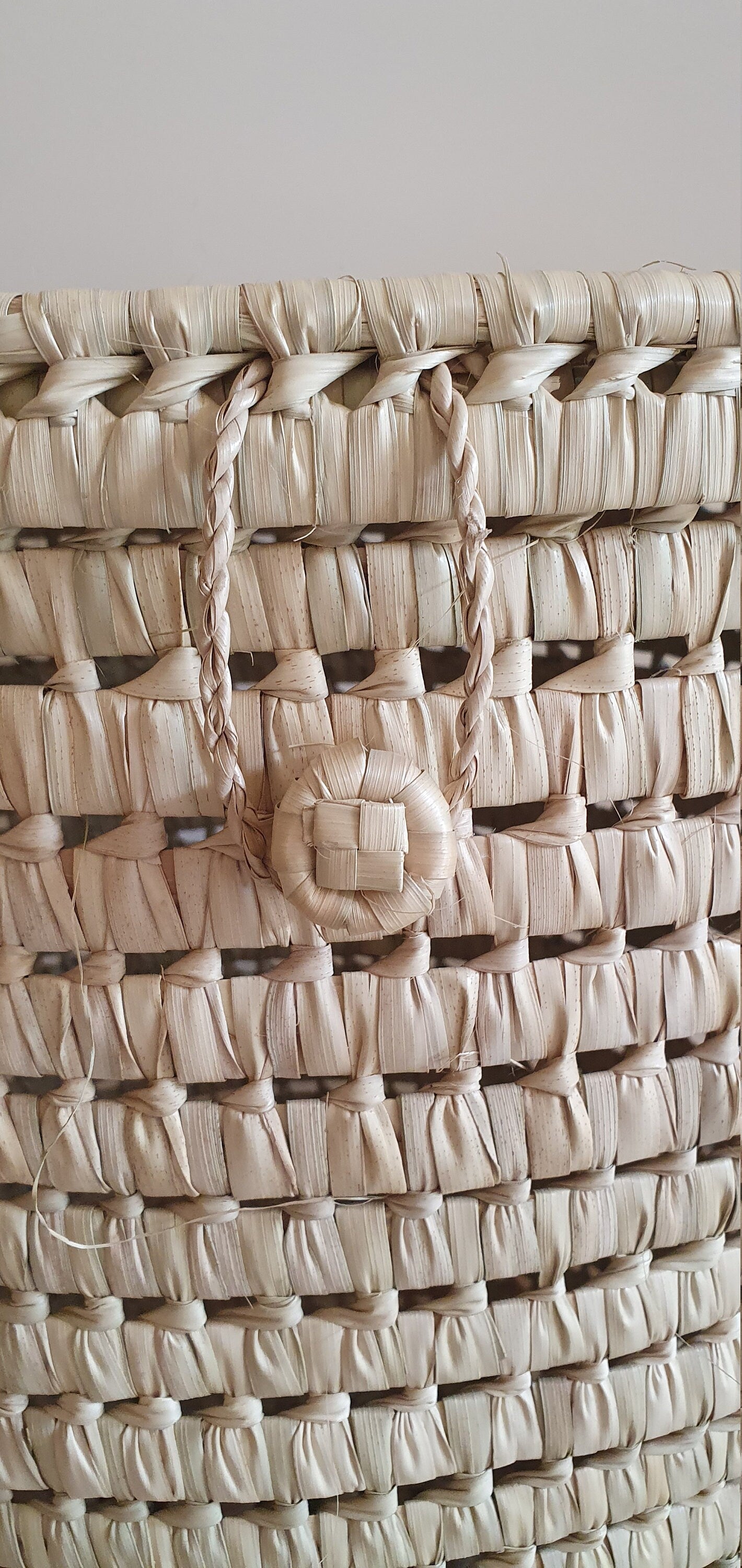 Décoration bohème avec un panier en feuilles de palmier, parfait pour une ambiance naturelle.