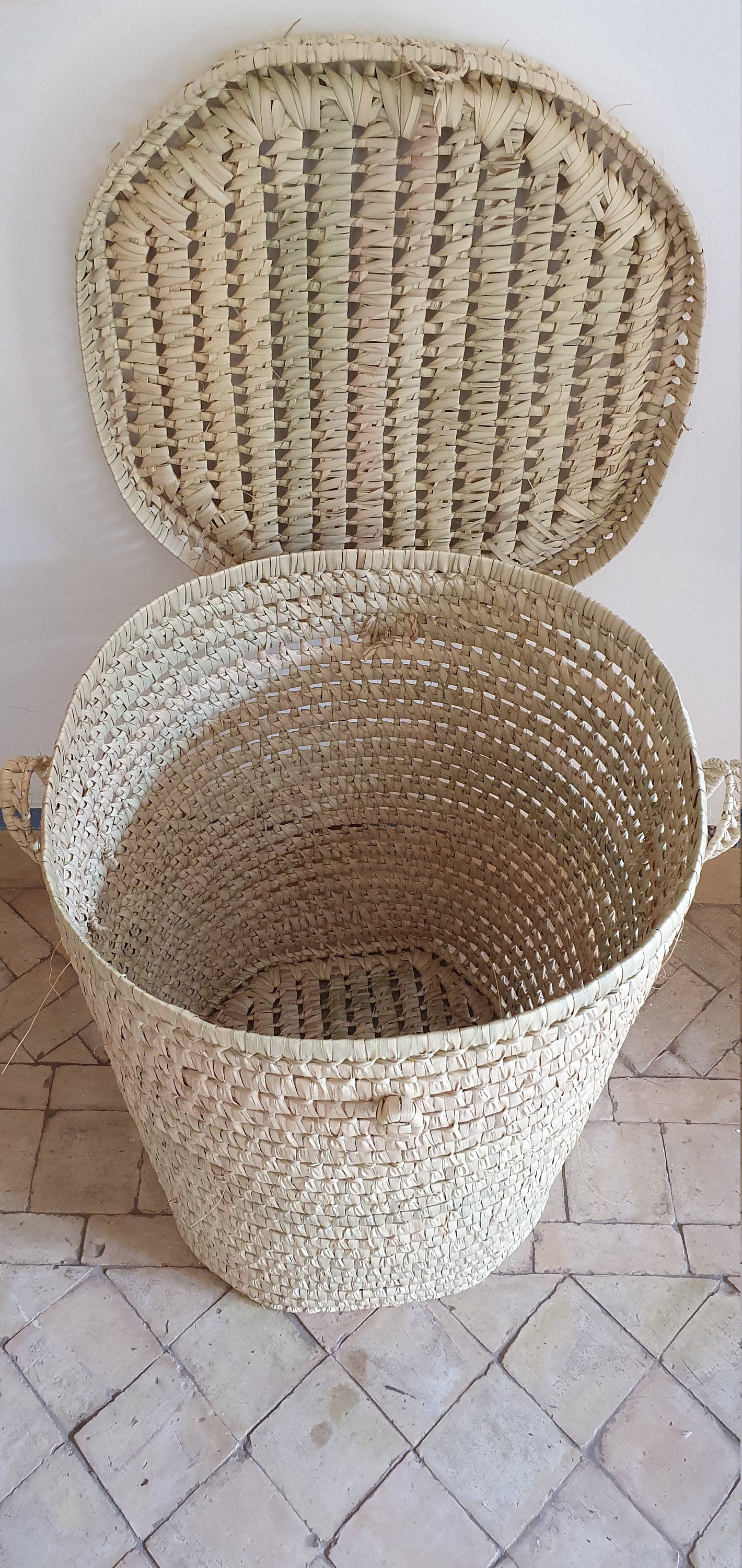 Un panier de rangement rond en feuilles de palmier, l'accessoire parfait pour une organisation élégante.