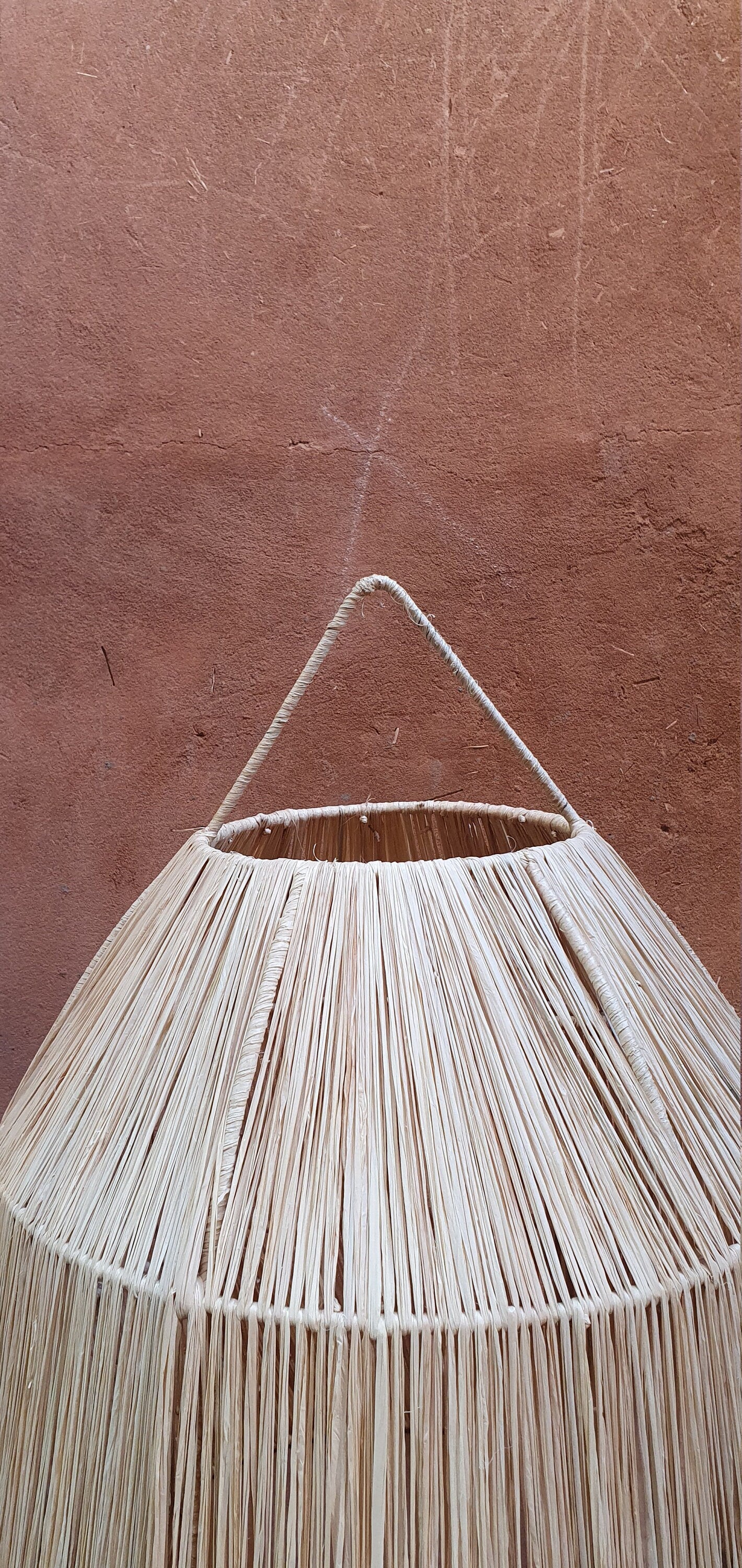 Lampe suspendue raffinée en raphia avec motif cloche et dentelle.