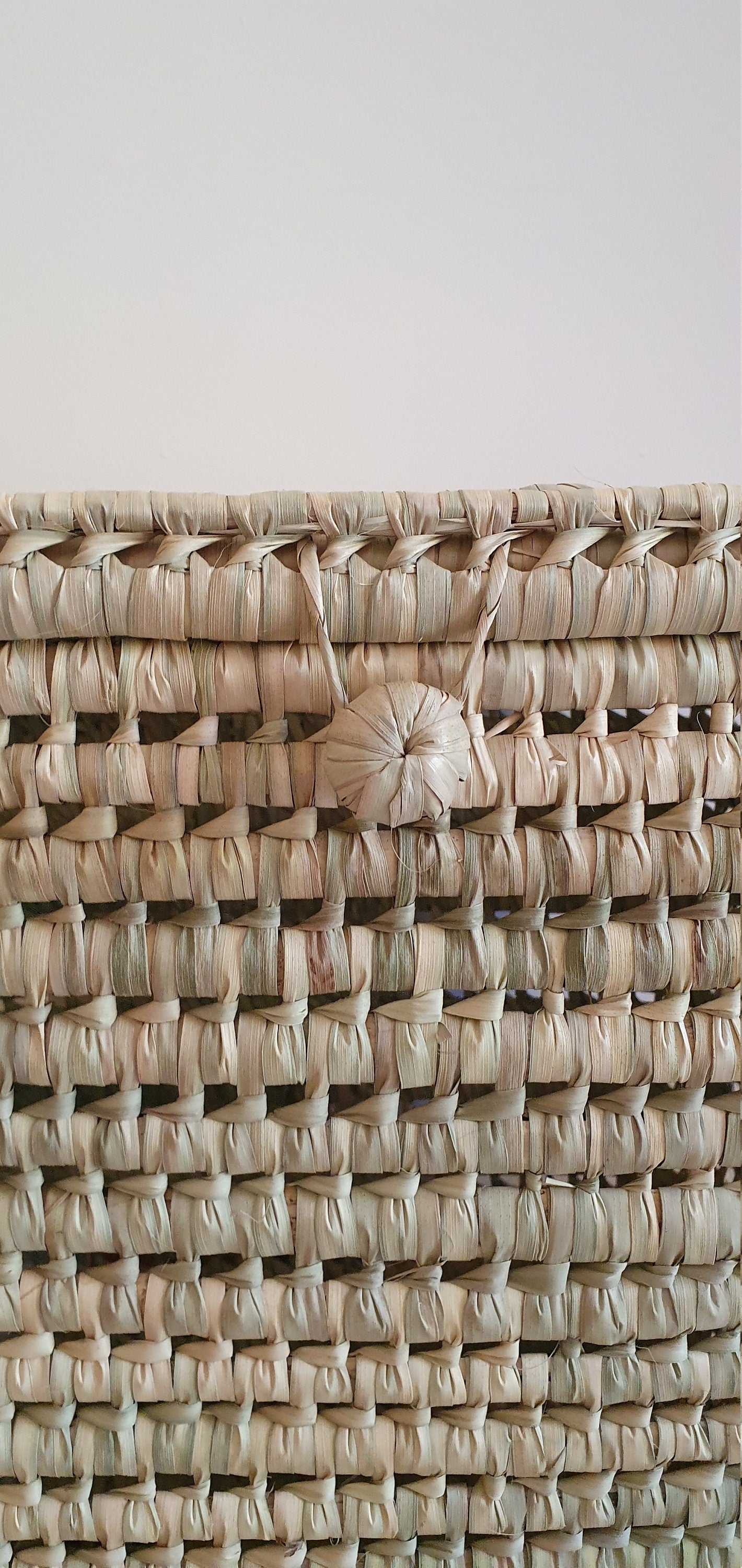 Panier de rangement tressé en feuilles de palmier, idéal pour organiser vos objets avec style rustique.