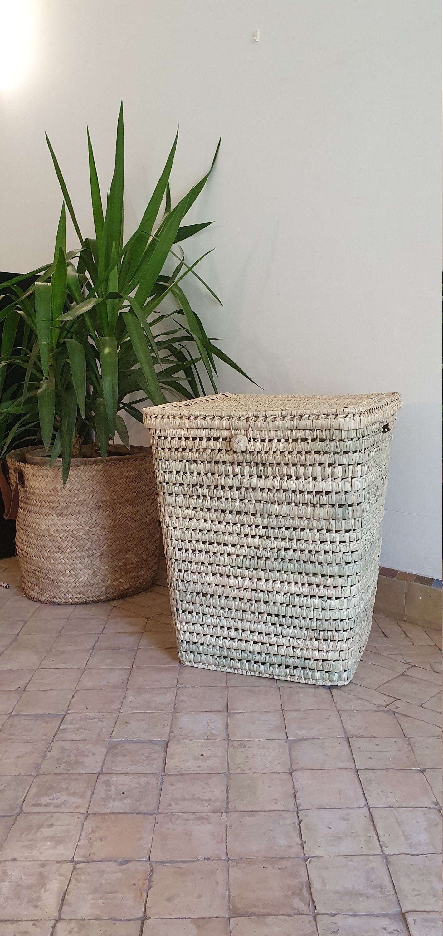 Vue rapprochée d'un panier en feuilles de palmier tressé à la main, mettant en valeur sa texture naturelle.