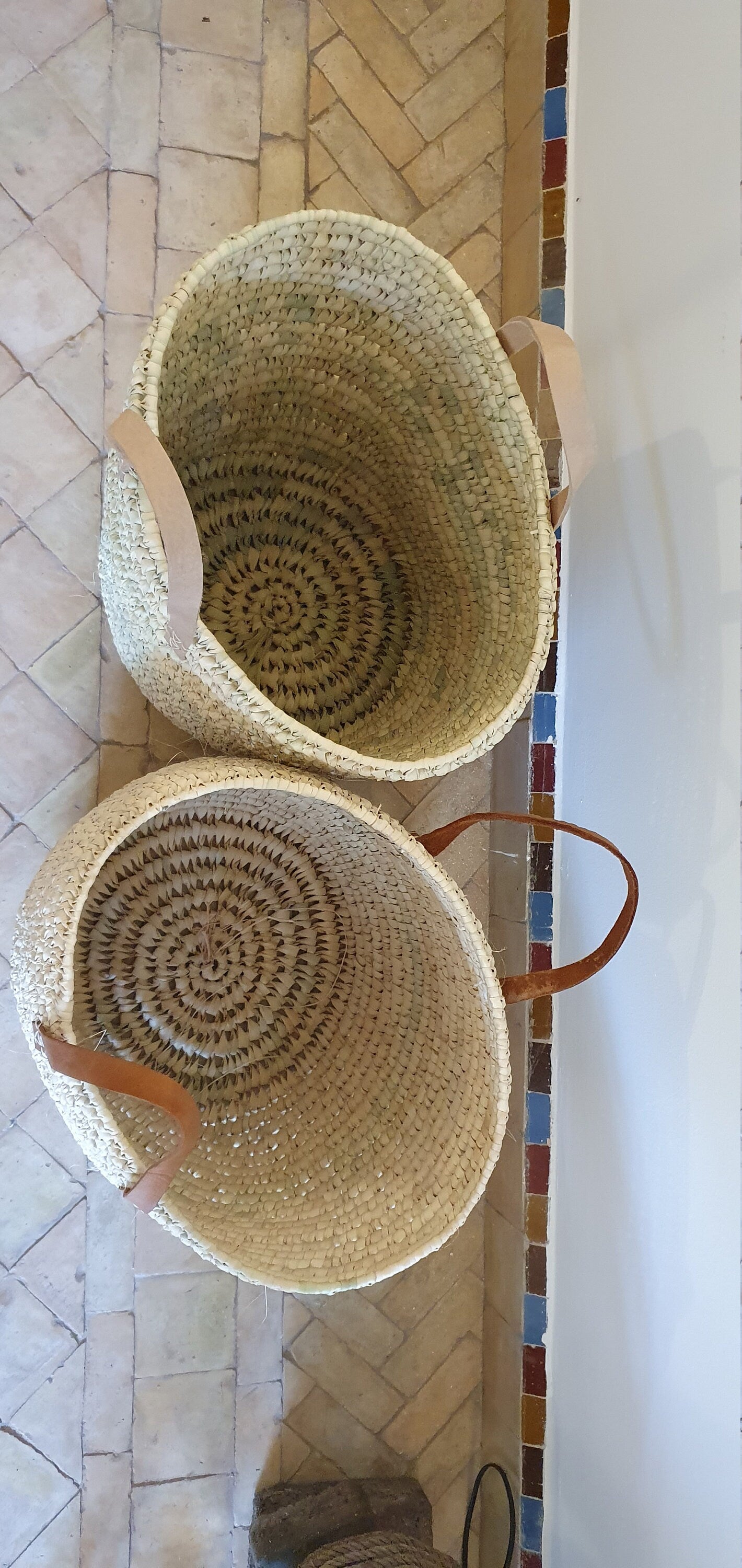 Panier en osier avec anses en cuir pour une touche de style.