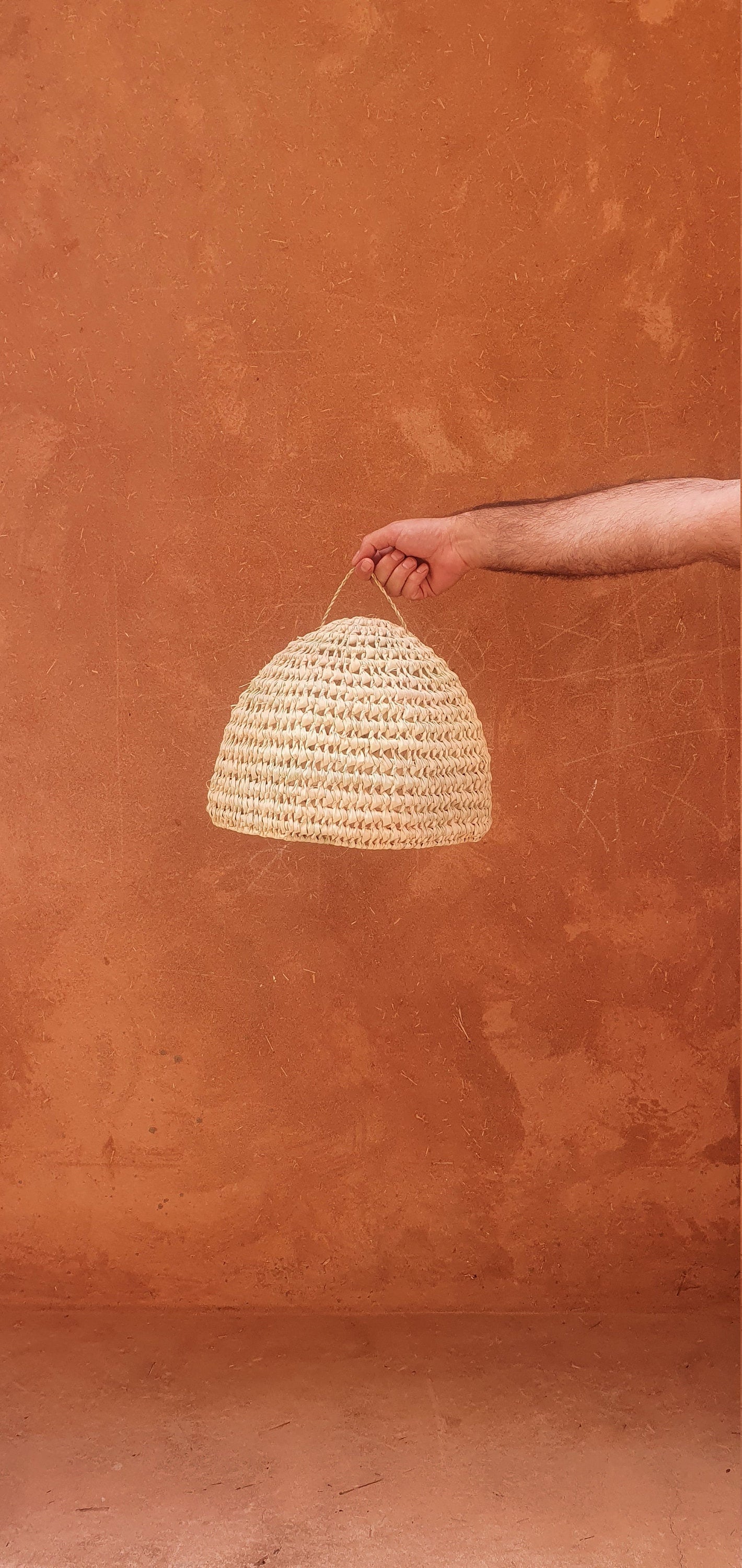 Suspension cloche en paille tressée dans un intérieur naturel.