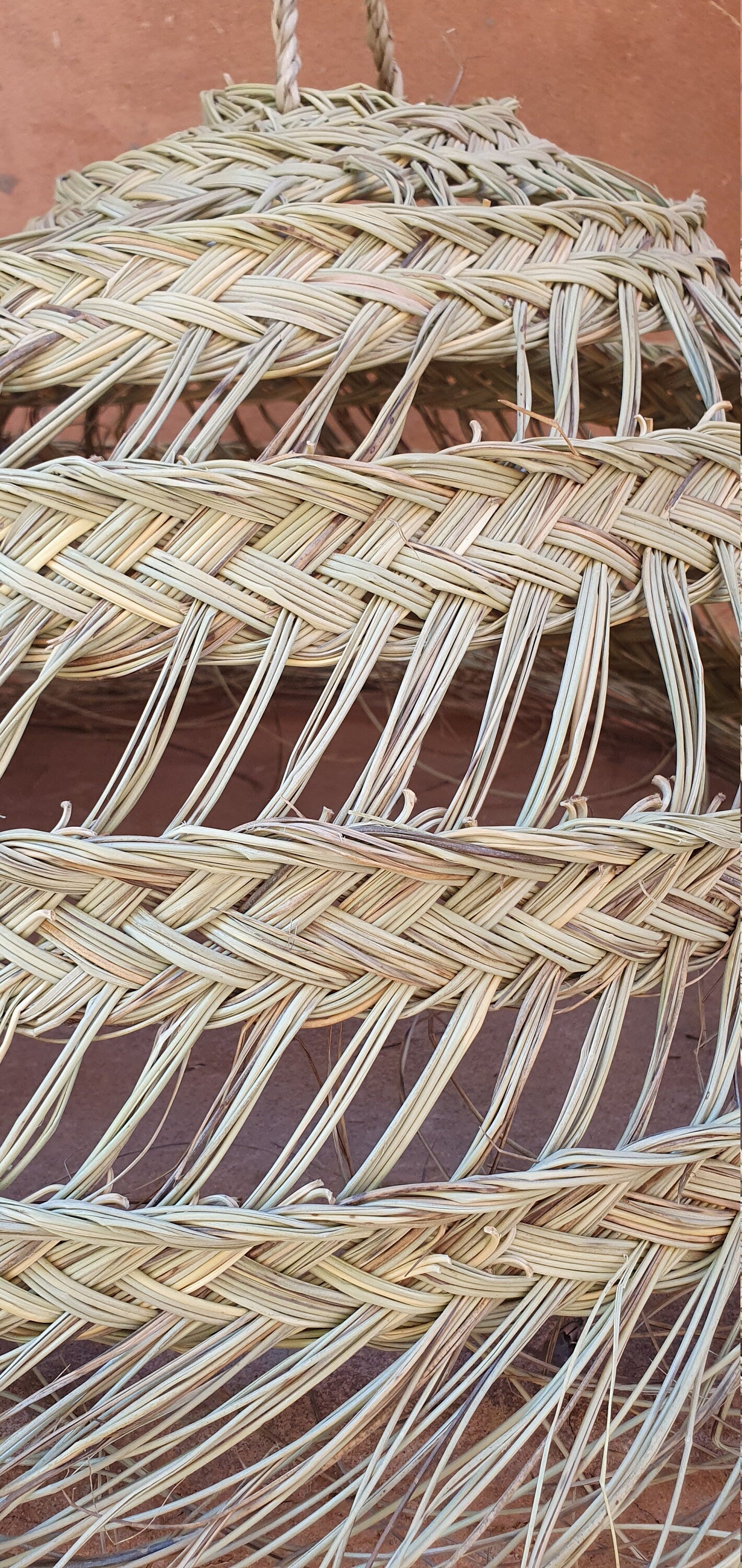 Luminaire suspendu artisanal en raphia et doum.