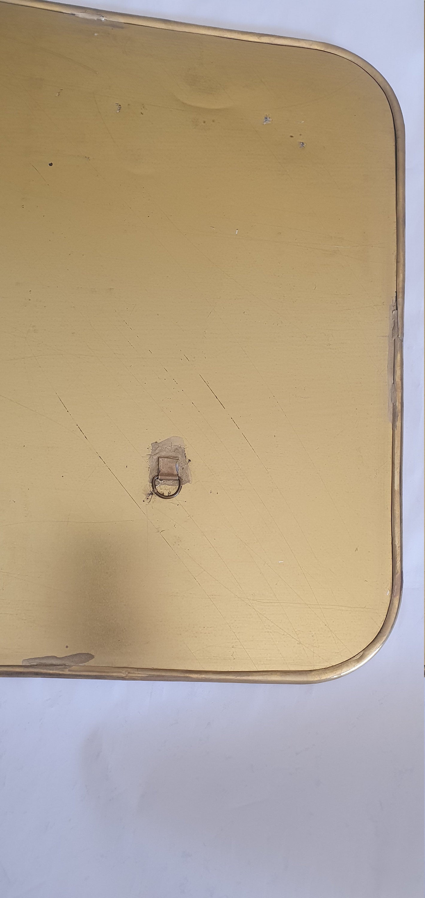 Gros plan d'un miroir carré fait main avec finition dorée.