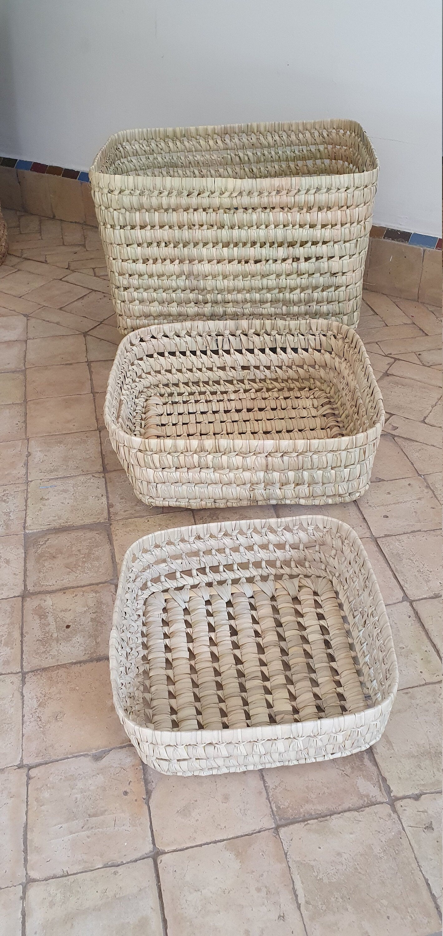 Vue rapprochée d'un panier tressé en feuilles de palmier et osier, mettant en valeur sa texture naturelle.