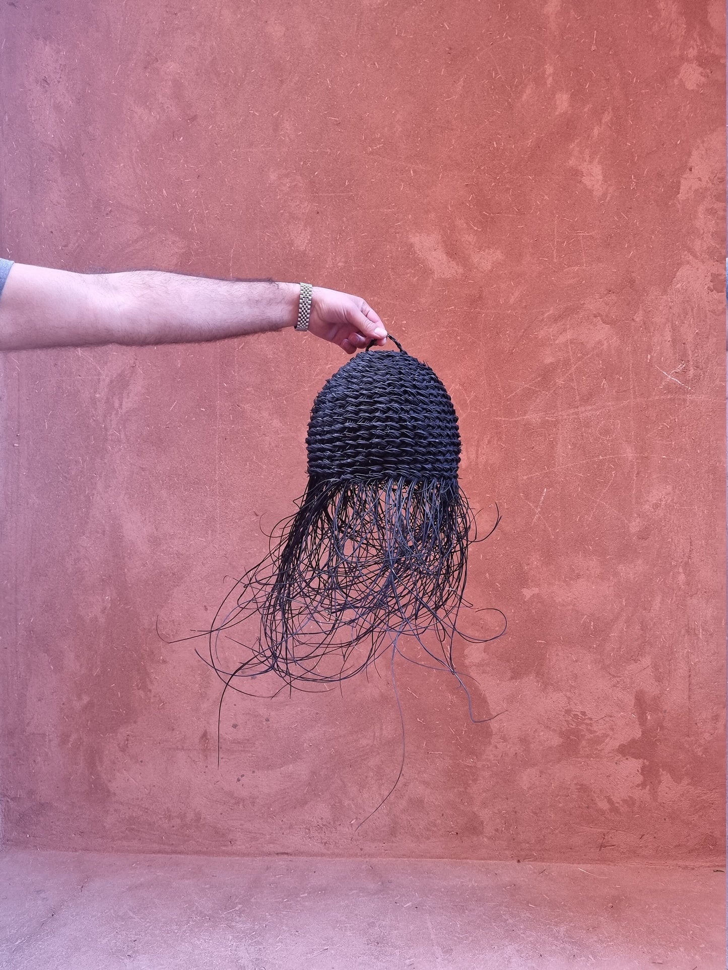 Luminaire suspendu en rotin et doum palmier, orné de franges élégantes.