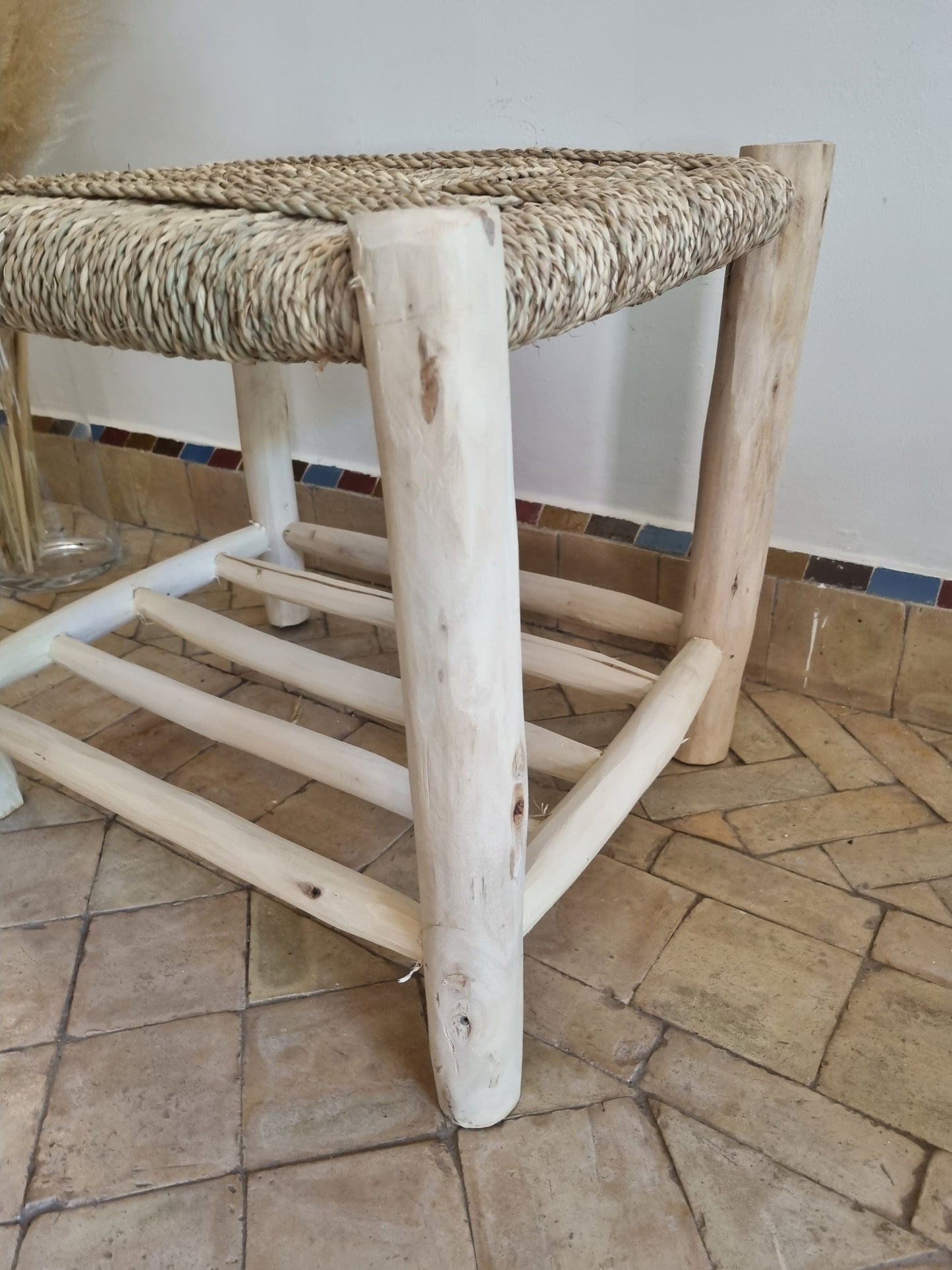 Une ambiance élégante avec un meuble en bois massif et un banc en tressage naturel, idéale pour la décoration intérieure