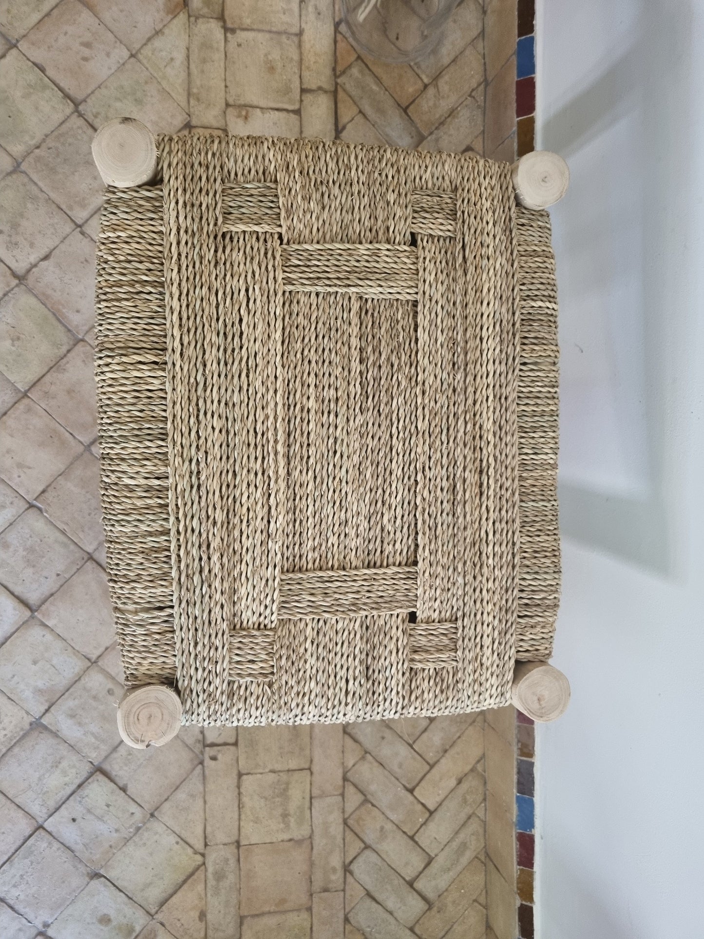 Un détail artistique du tressage naturel sur le banc en bois massif, soulignant l'artisanat de la pièce