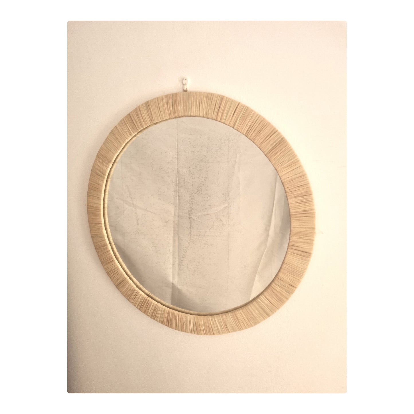 Image d'un miroir rond mural en raphia.