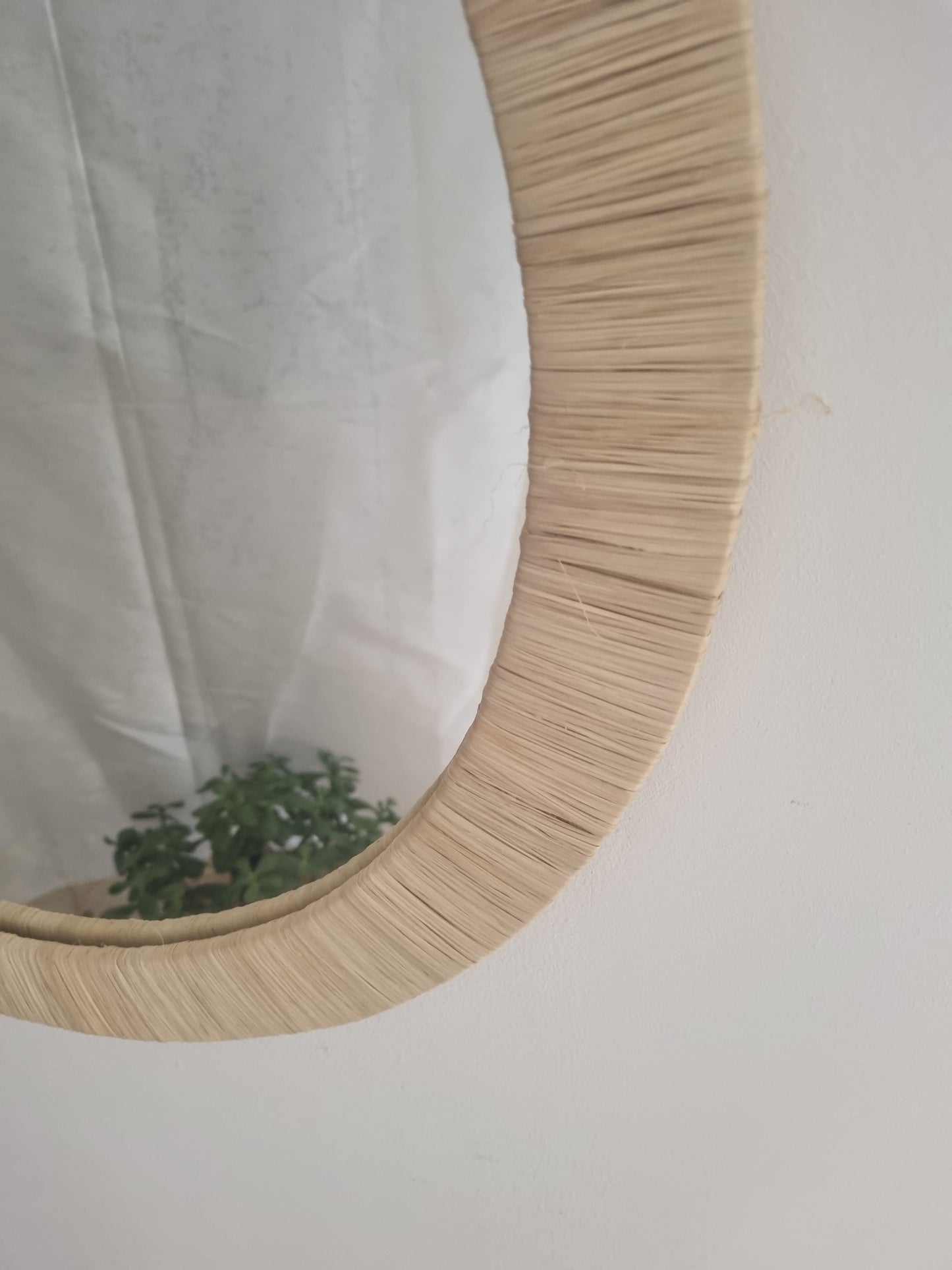 Miroir rond mural avec tressage en raphia.