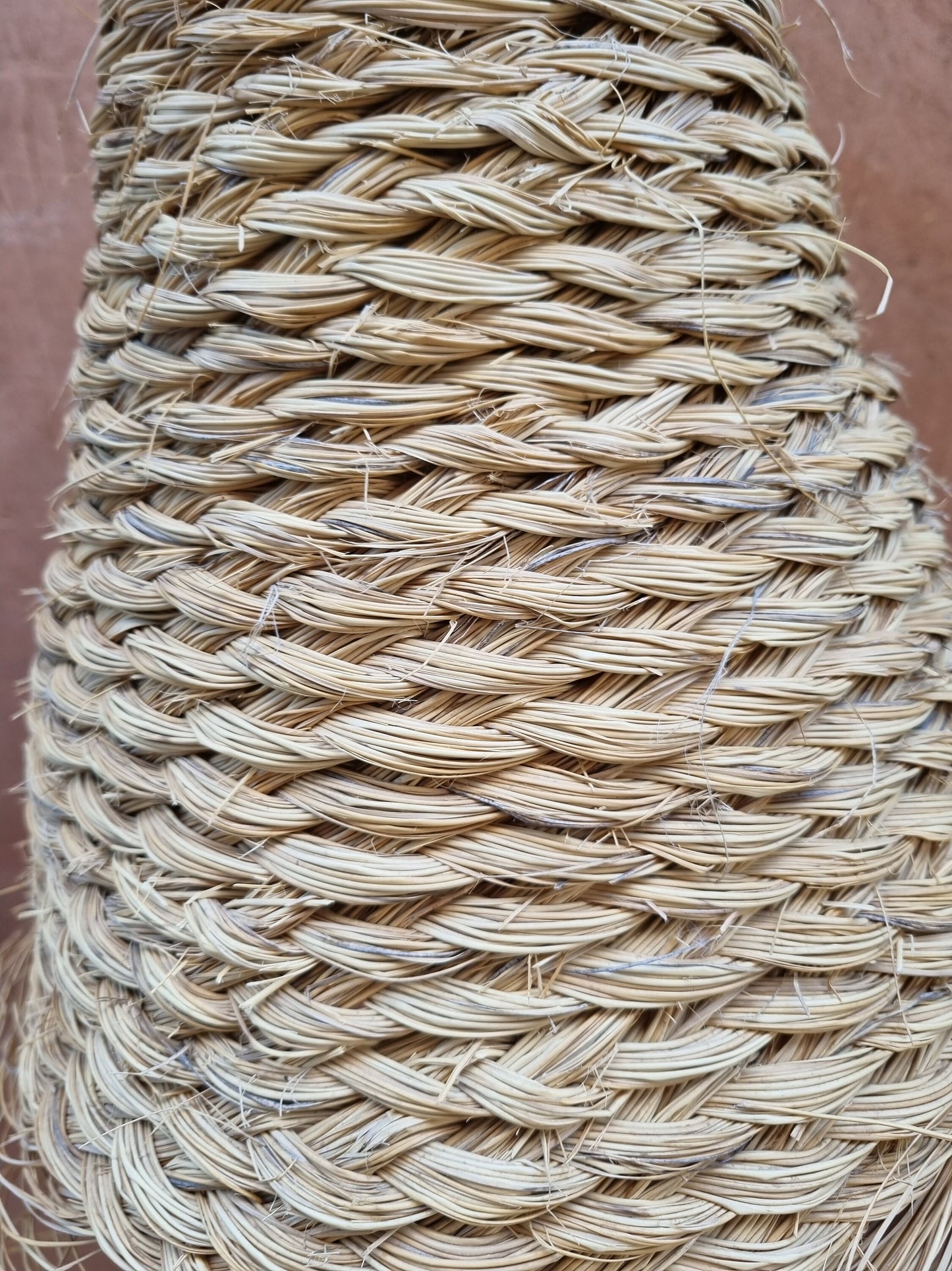 Conical suspension lamp crafted from natural doum fibers.