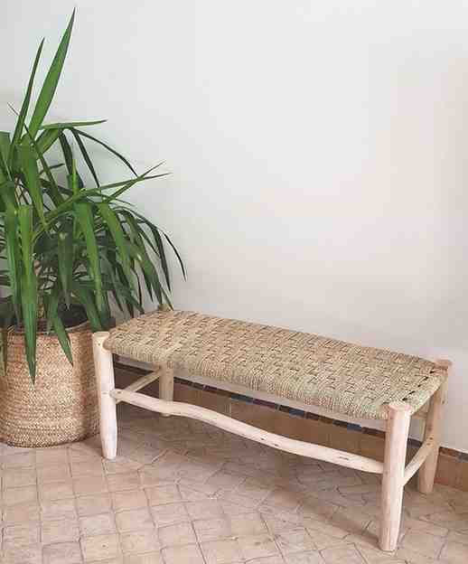 A beautifully crafted Moroccan wooden bench adorned with intricate weaving