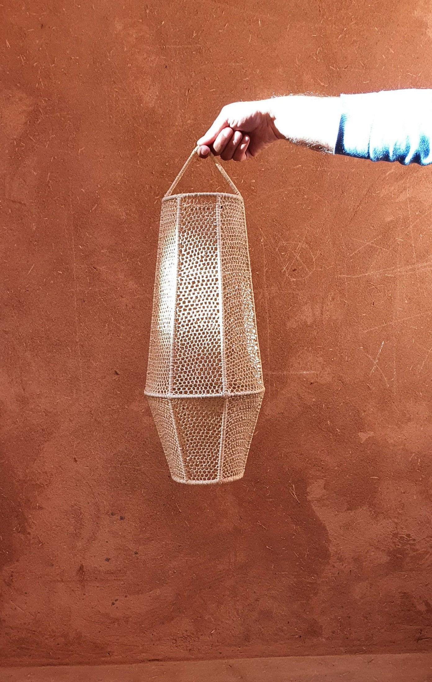 Suspension lanterne marocaine en raphia avec détails de dentelle.