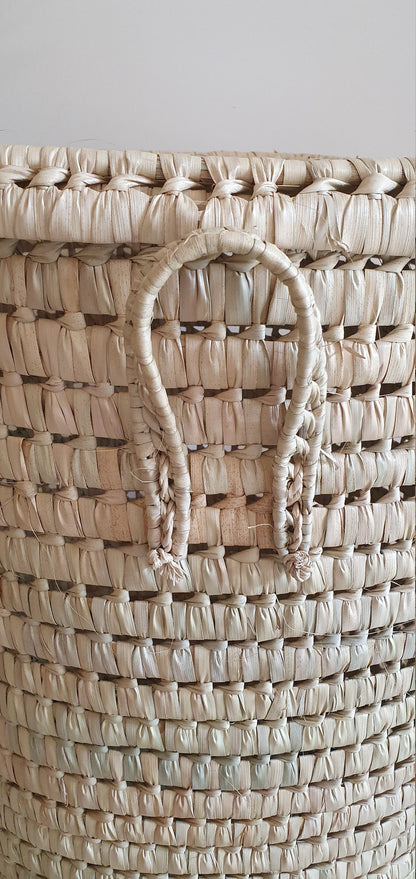 Ce panier rond en palmier est un accessoire de décoration intérieure écologique et durable.