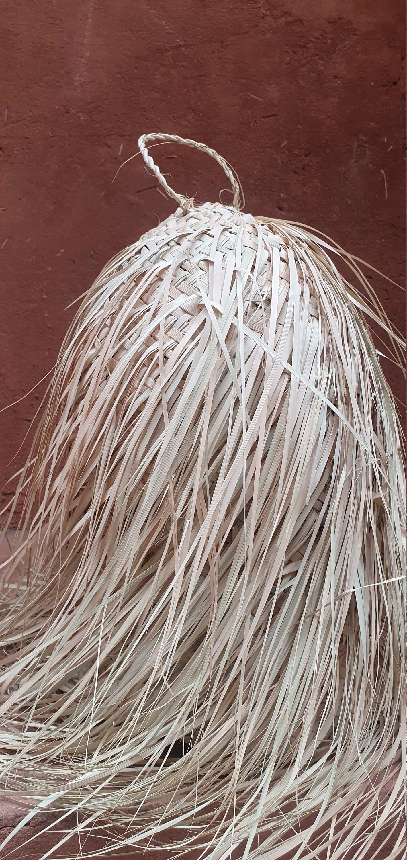 Luminaire durable en fibre de feuille de palmier en forme de cône.