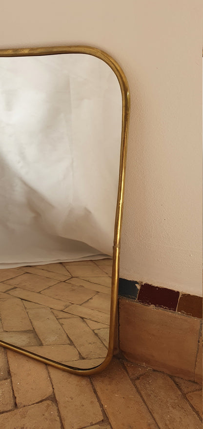Gros plan d'un miroir carré fait main, mettant en valeur son artisanat unique et sa teinte dorée.