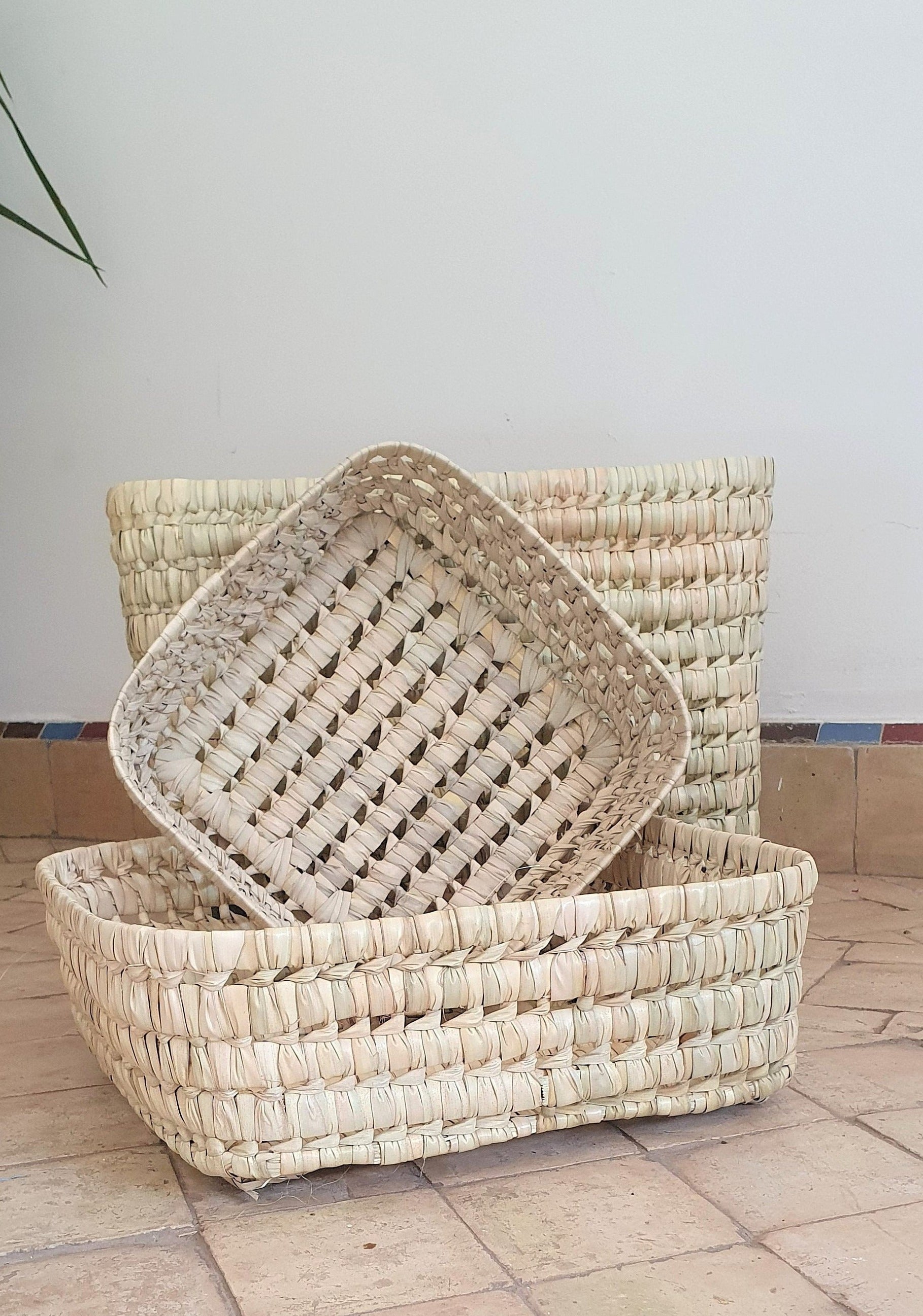 Un panier en feuilles de palmier et osier, idéal pour organiser vos objets avec style rustique.