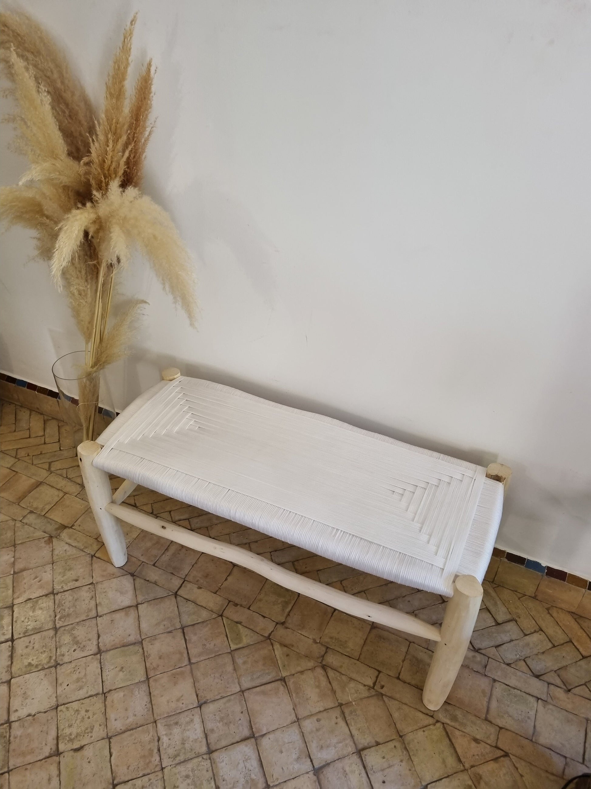 Moroccan bench with solid wood construction and intricate wire braiding.