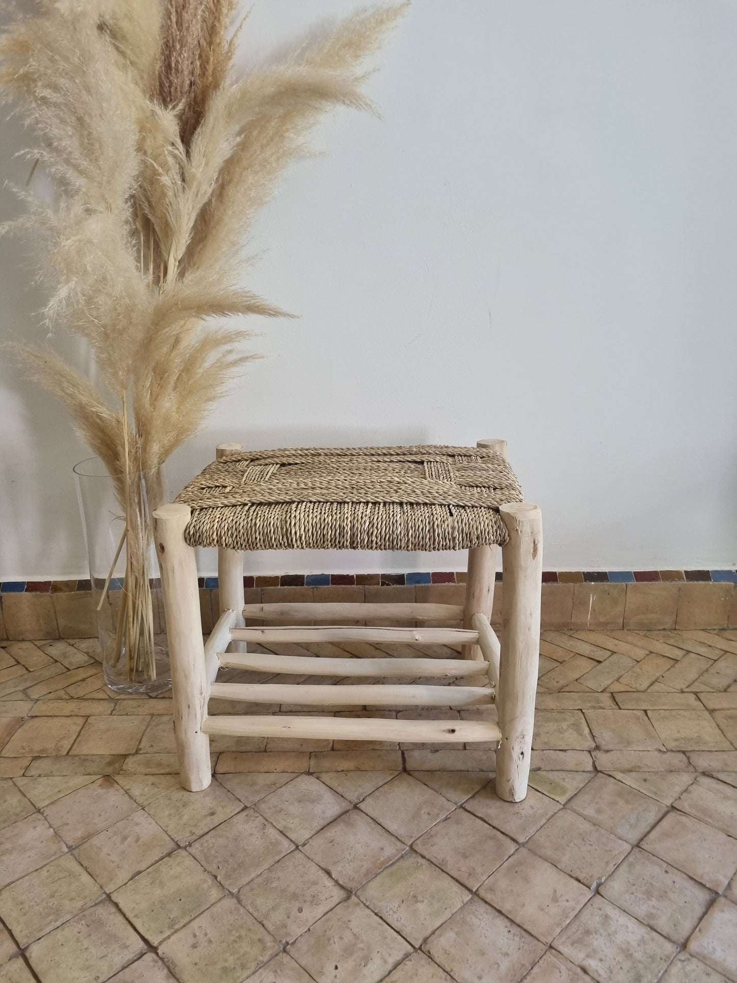 Un meuble en bois massif avec un banc doté d'un tressage naturel, créant une atmosphère accueillante dans un espace