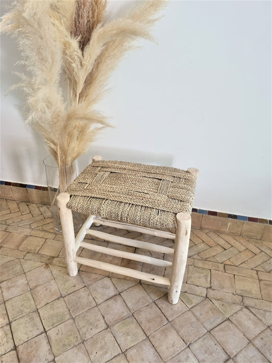 Un meuble en bois massif avec un banc doté d'un tressage naturel, offrant une esthétique rustique et chaleureuse